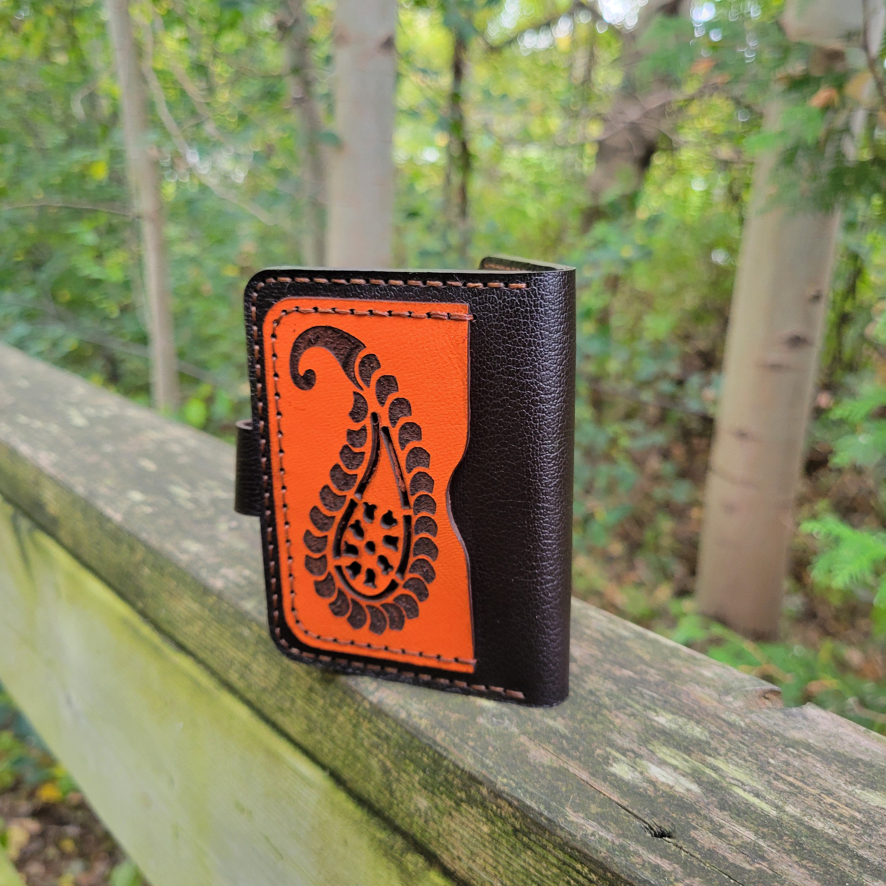 Handcrafted leather cardholder from HagorArts, featuring a bold orange paisley pattern and premium brown leather.
