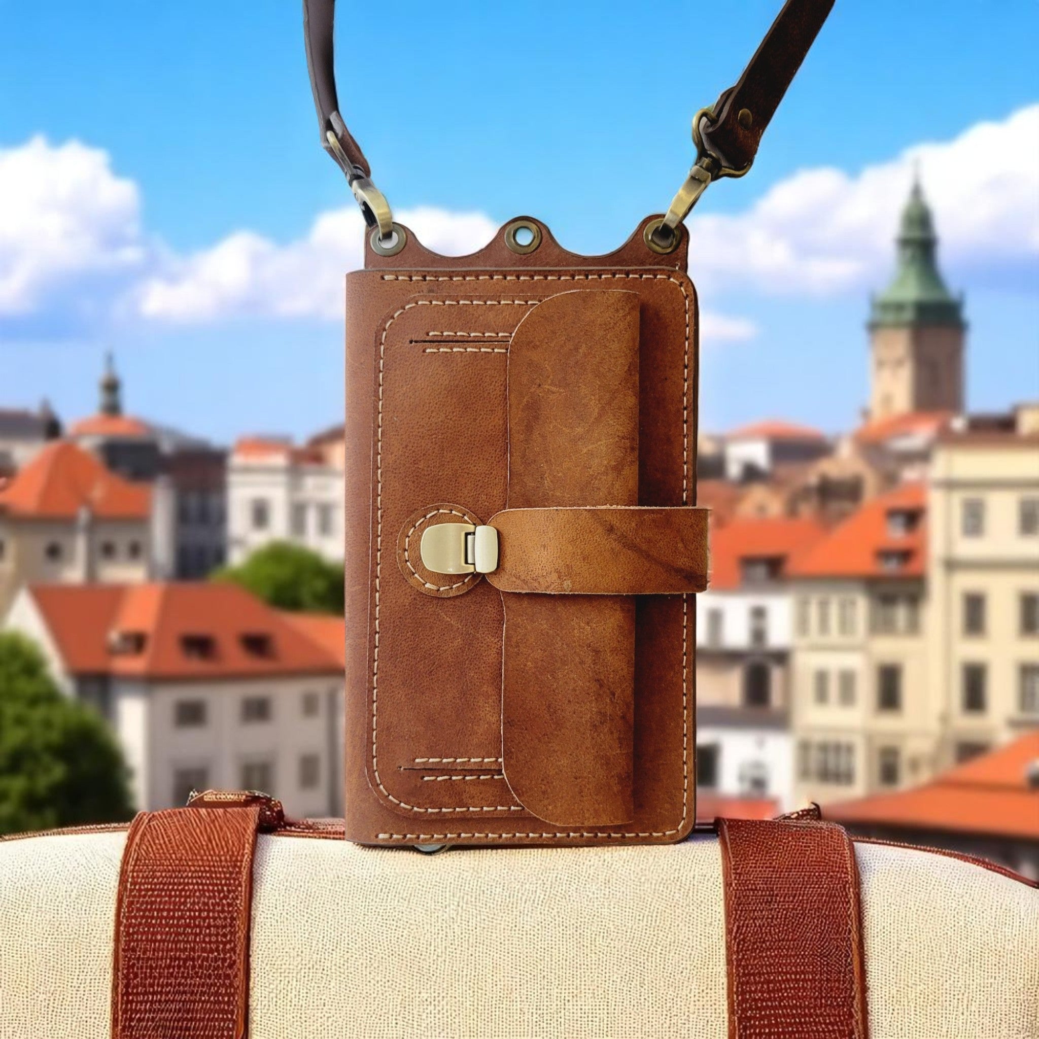 Brown leather crossbody bag with a cityscape in the background