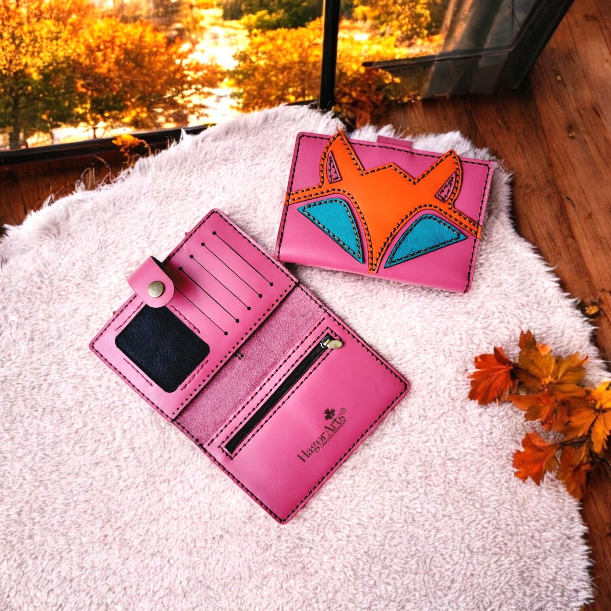 A handcrafted leather wallet with a cute fox design, displayed open to show multiple card slots, a zippered compartment, and a transparent ID slot.