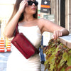 Woman with a red shoulder bag and sunglasses in an urban setting