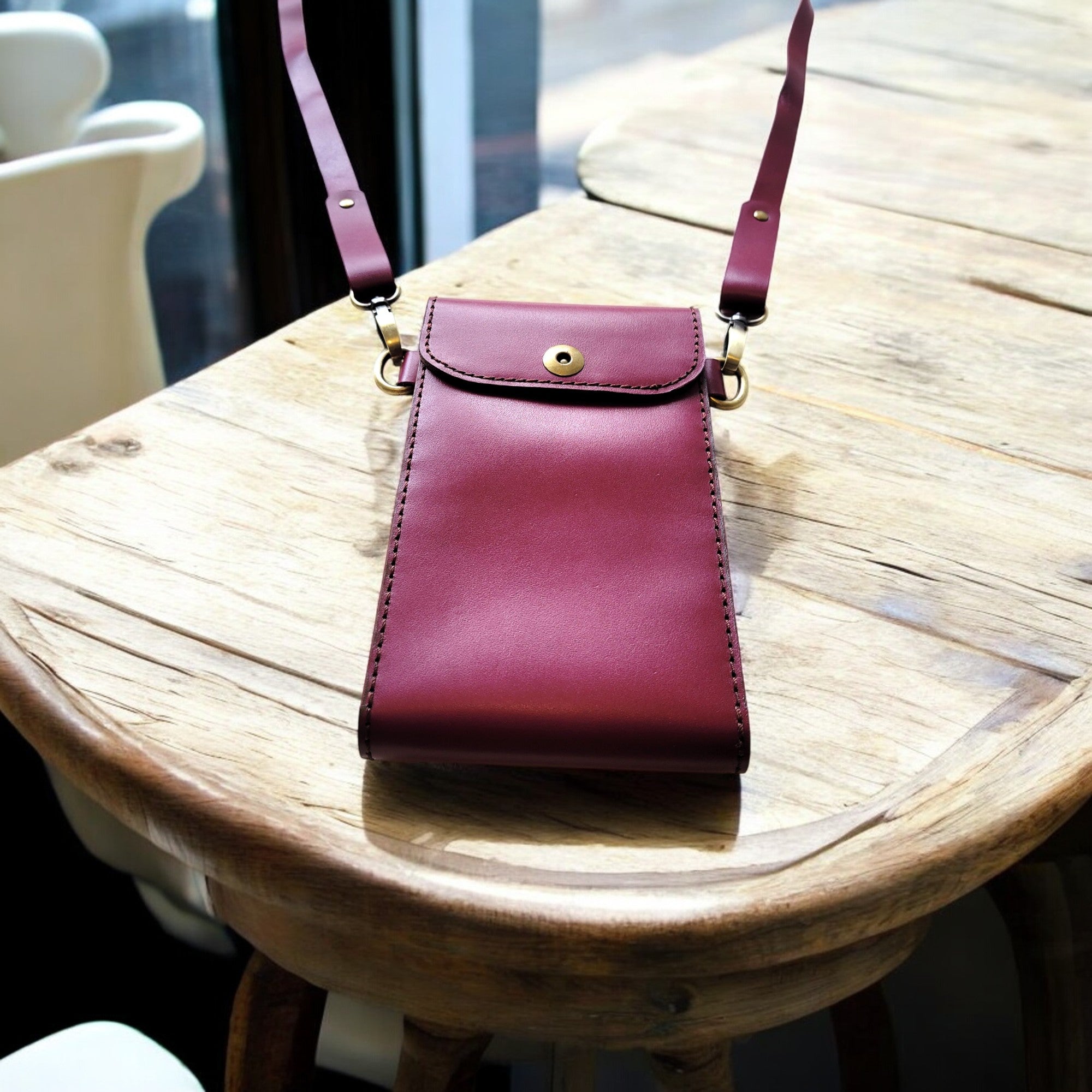 Claret C1 slim full‑grain leather crossbody (20×13×2 cm) with adjustable strap and clean snap closure.