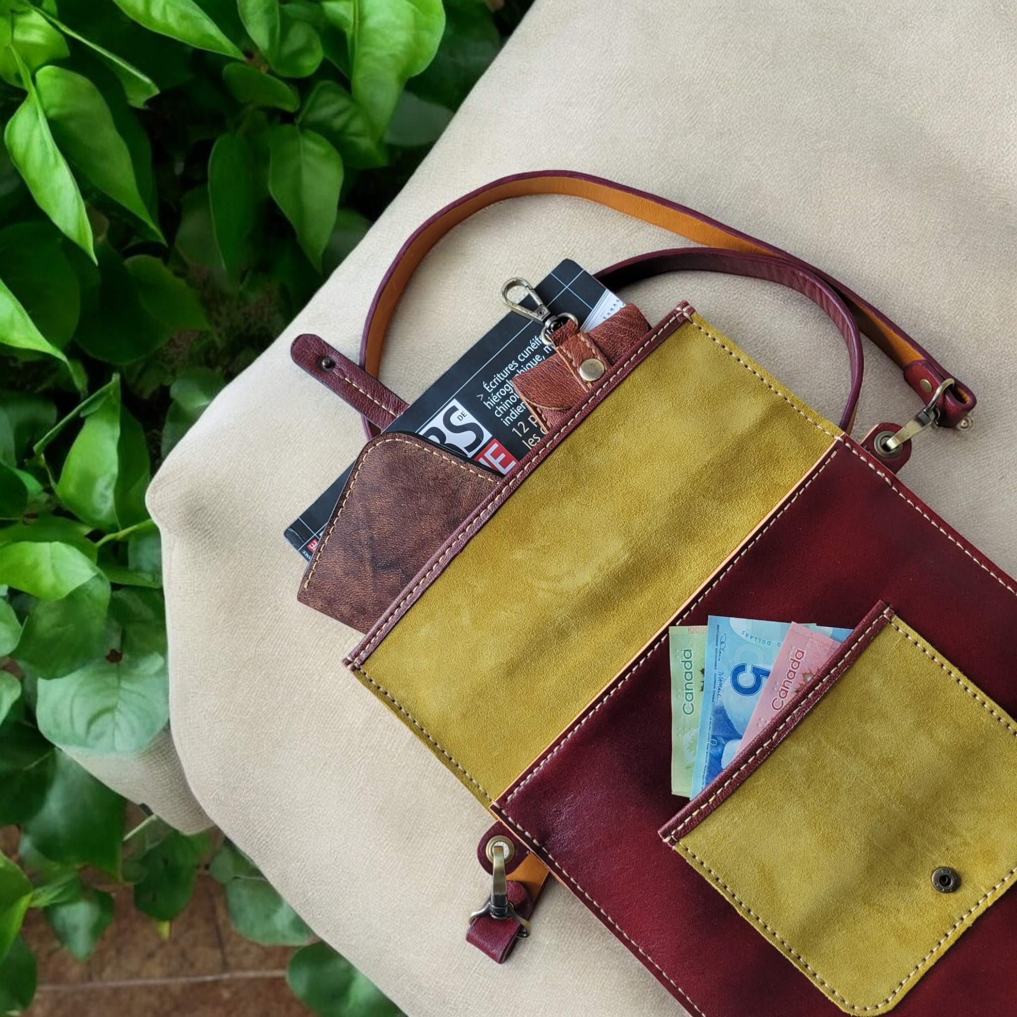 Olive green leather crossbody bag with crimson flap and hand-stitched edges