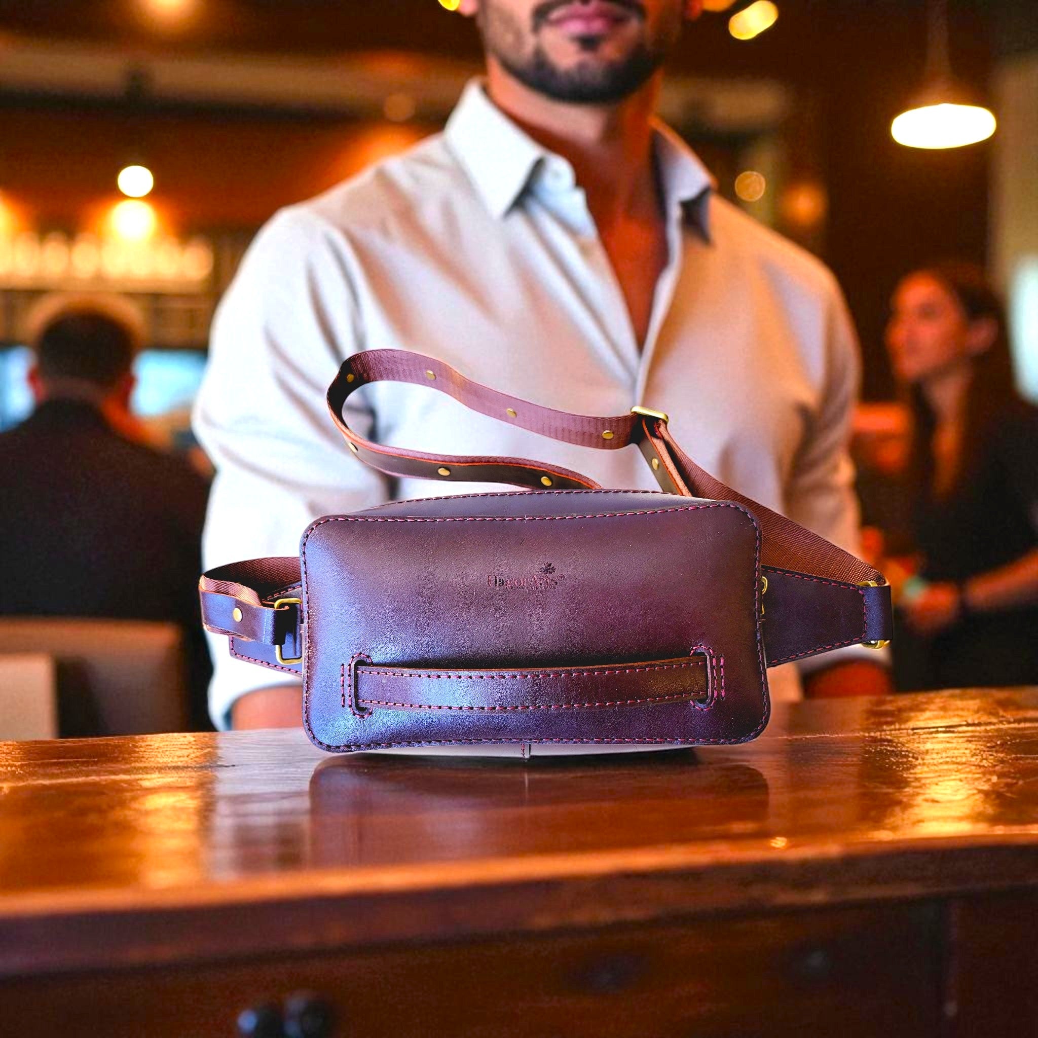 Purple leather waist bag on a wooden table with a blurred background of people.