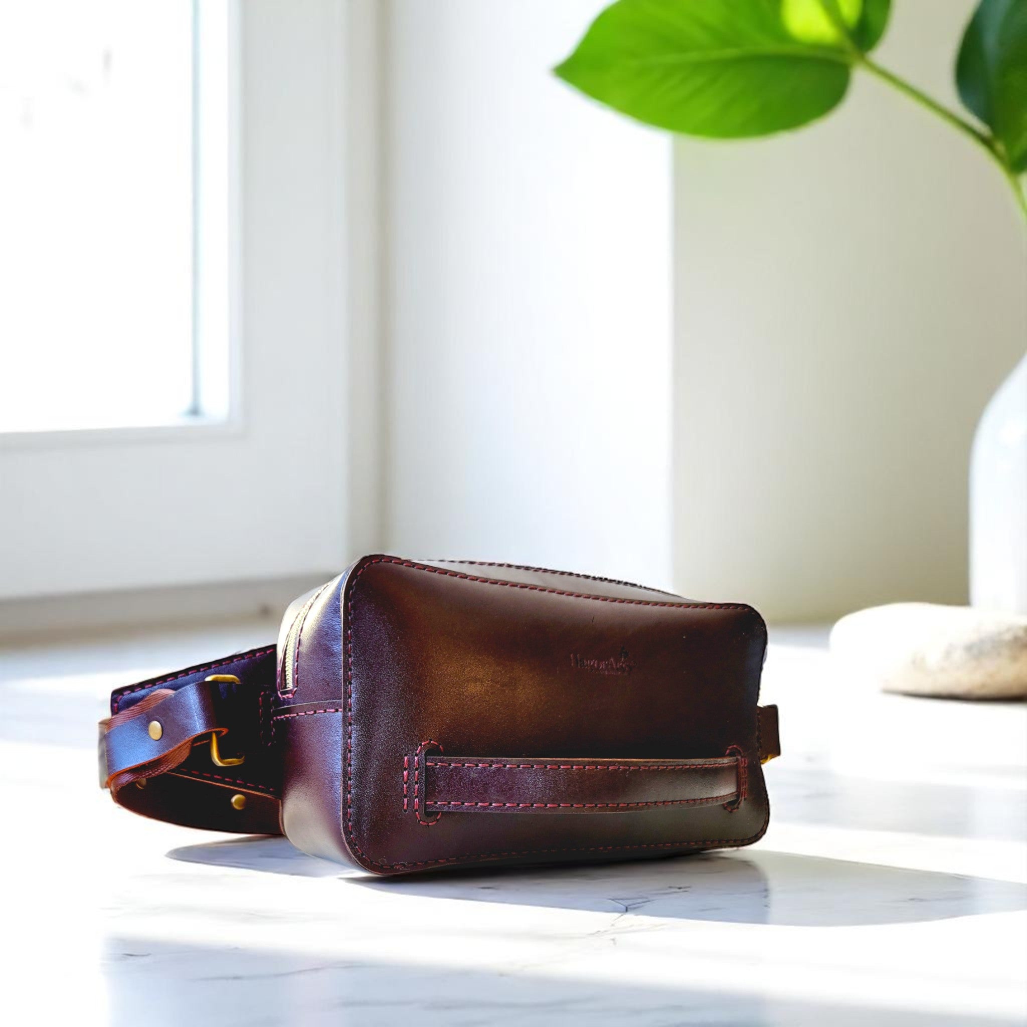 Brown leather bag on a white surface with a blurred background