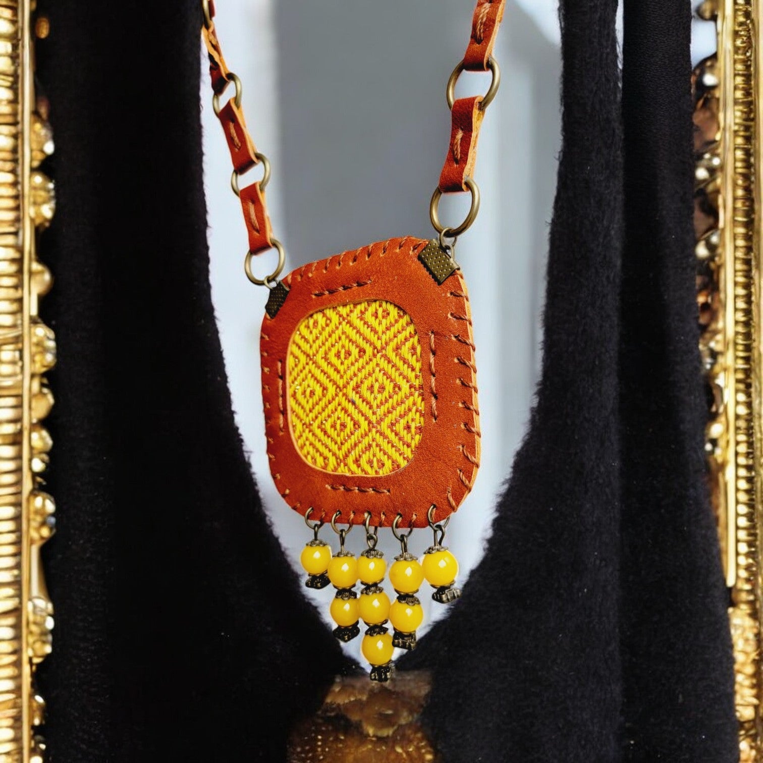 “Close-up of honey leather frame with whip-stitching around geometric woven panel — Velora C3.