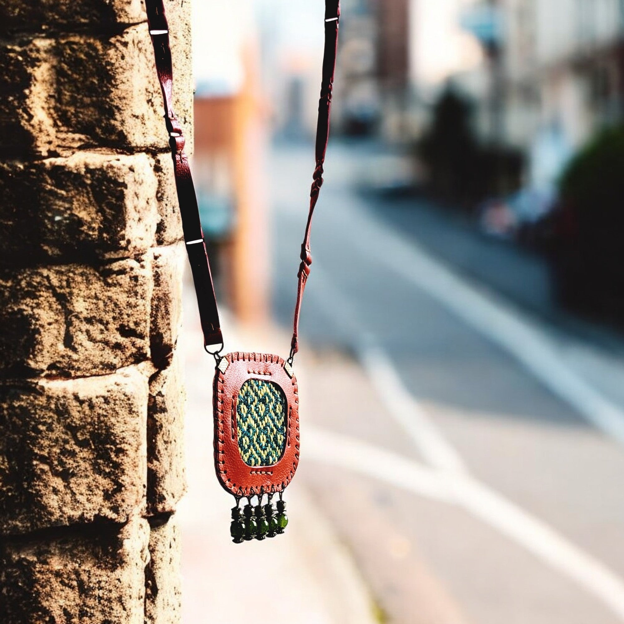 Leather-link strap joined with antique-brass rings for flexibility and style.