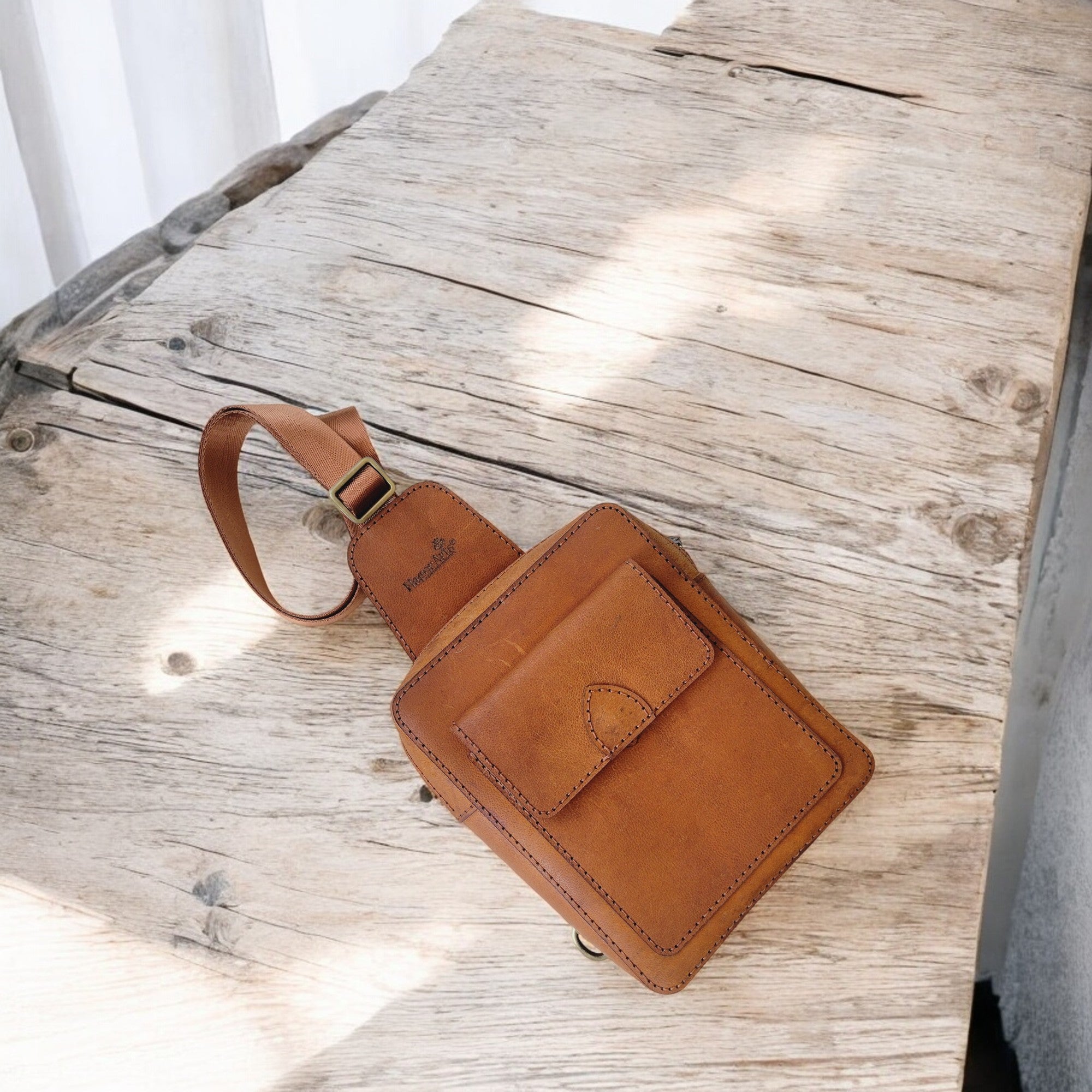 Brass-tone metal hardware; structured body that holds its shape.