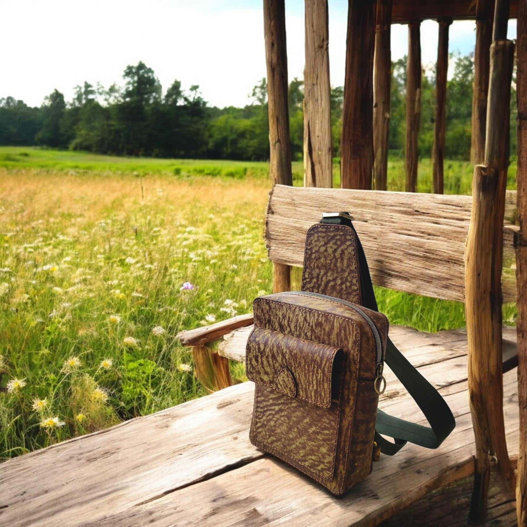 Odyssey C2 camel-leather sling with earth-texture, 21×17×6 cm, top zipper, rear zip pocket, and front flap pocket.