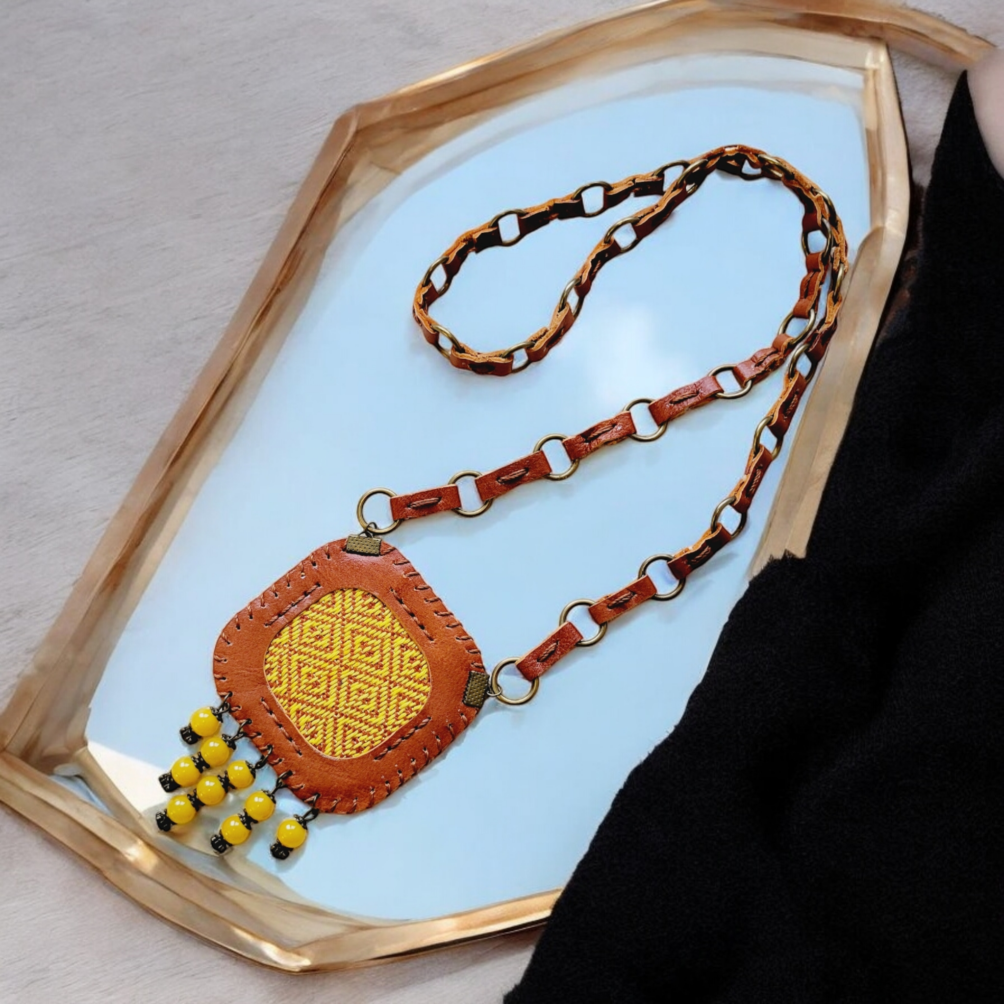 Leather-link strap with antique-brass rings; lightweight yet sturdy.