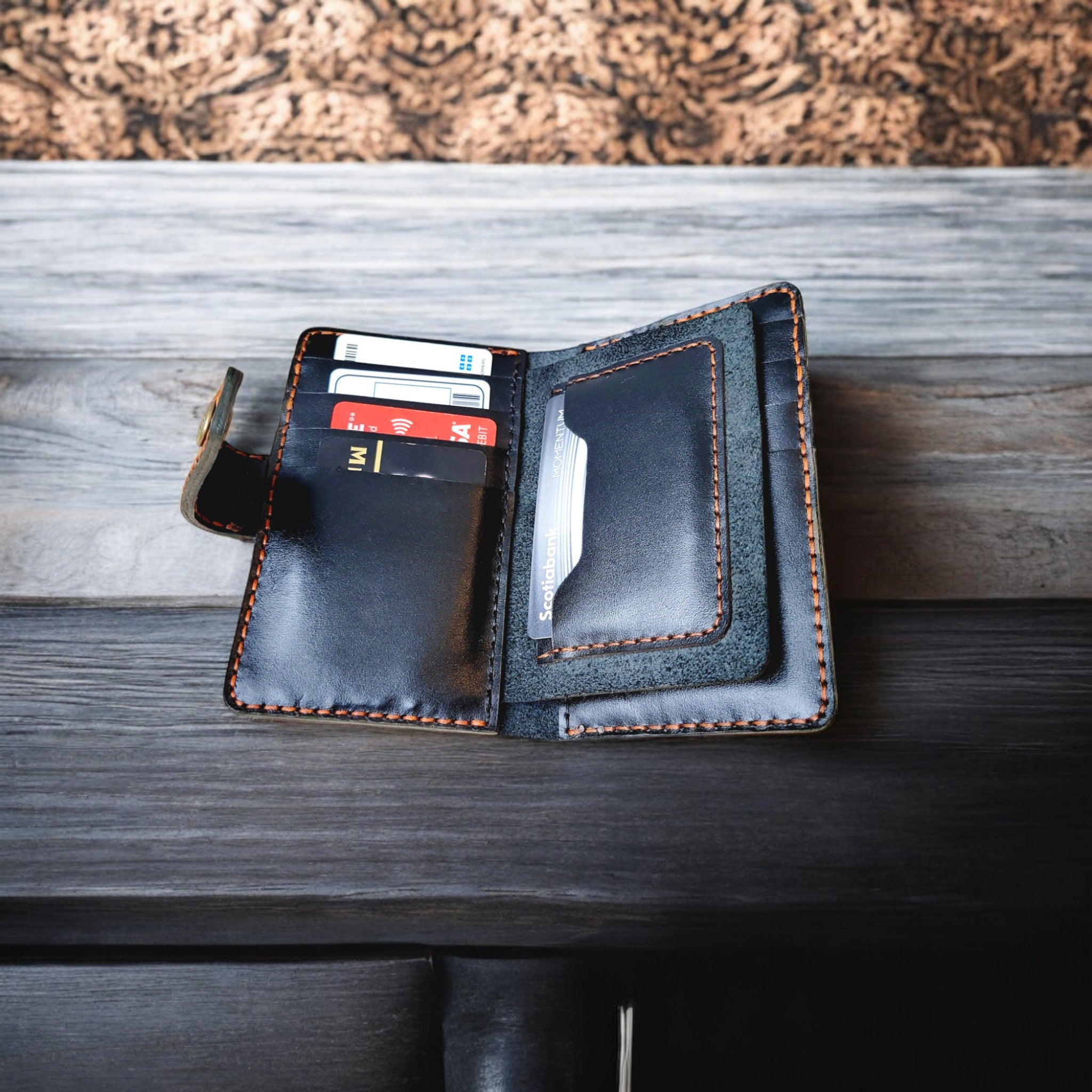 Prestige Collection C1 black leather cardholder displayed on a wooden surface.