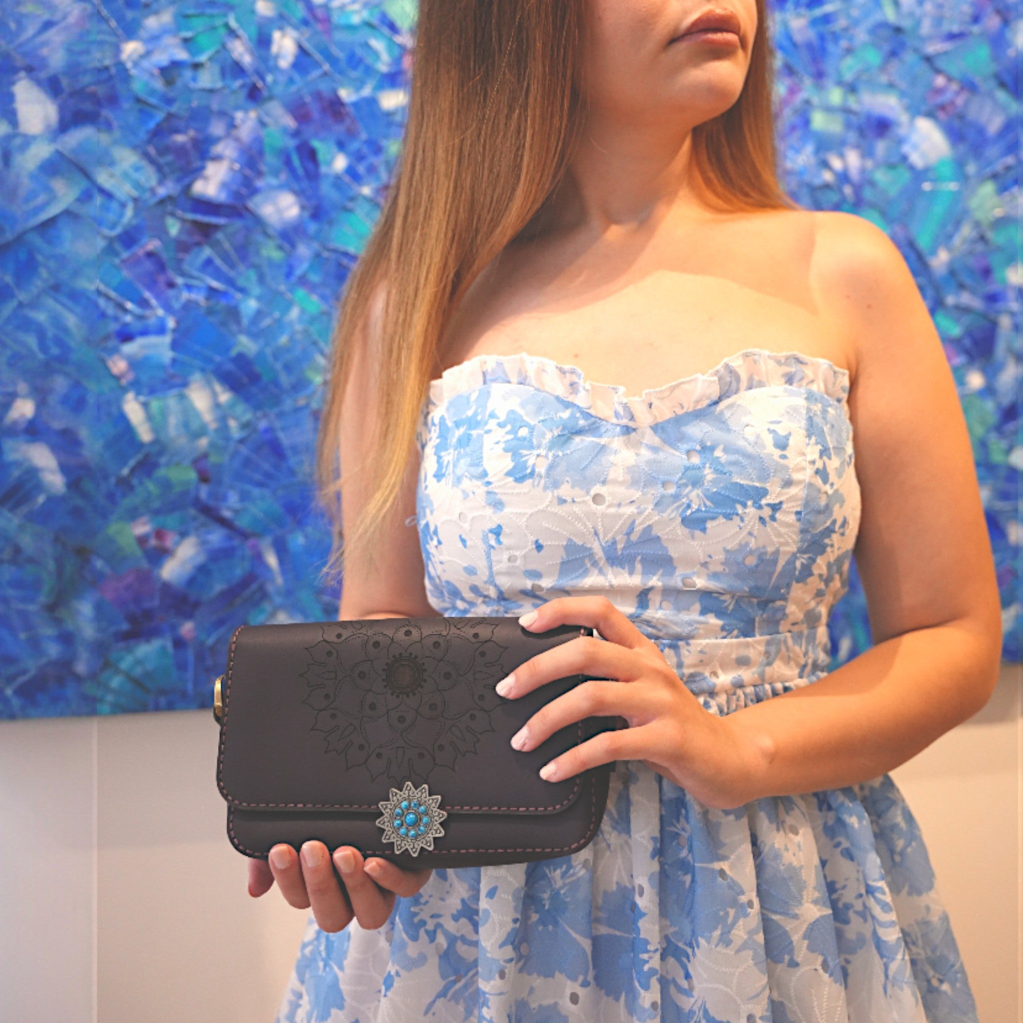 “Deep violet leather crossbody bag with card slots and engraved floral mandala.”