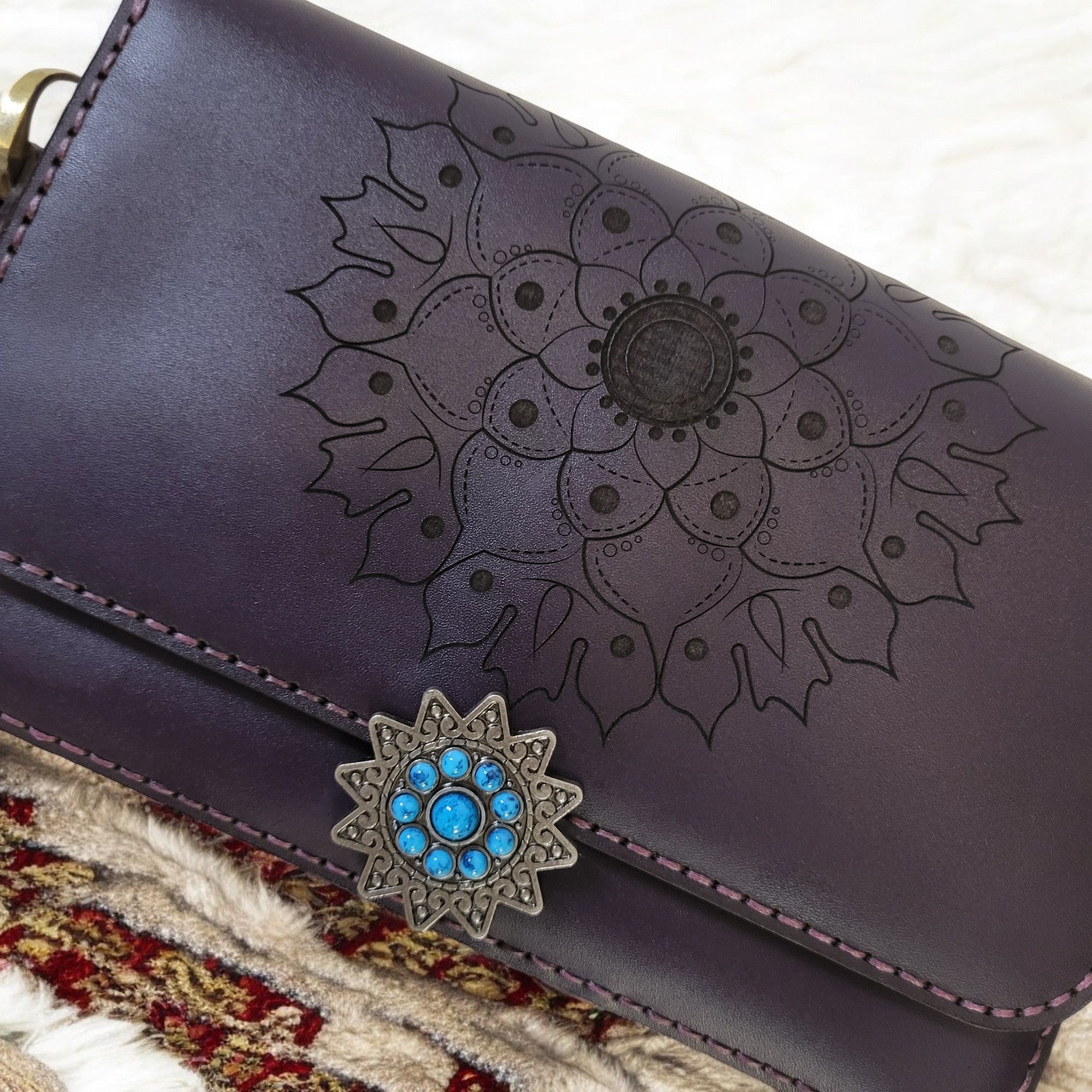 “Engraved mandala design on purple leather crossbody bag — artisan craftsmanship.”